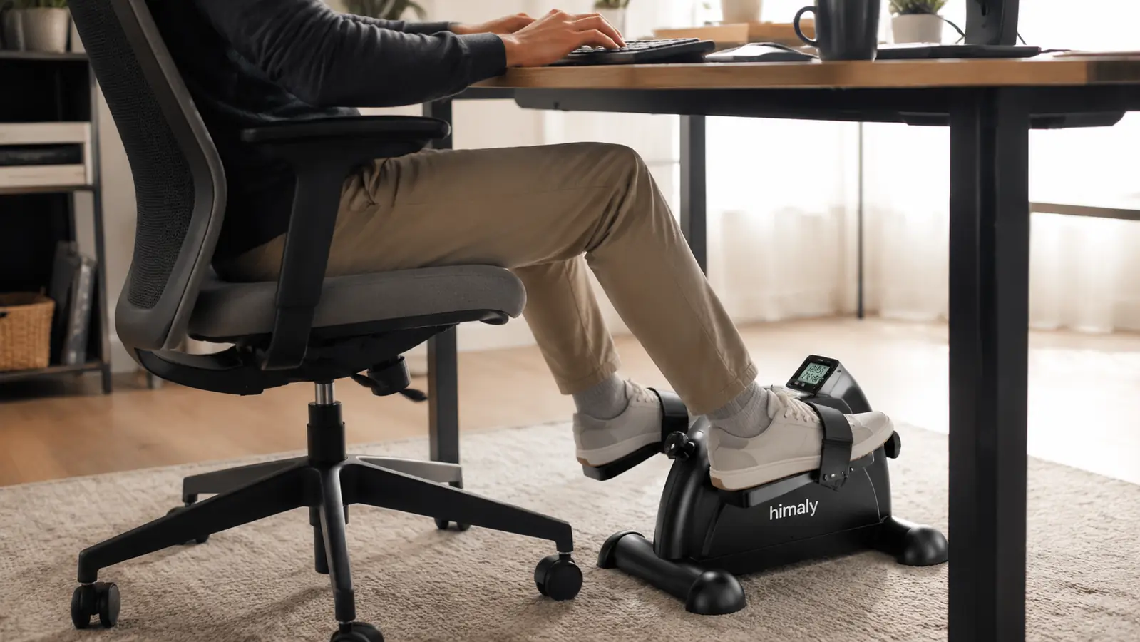 A remote worker's legs pedaling an under-desk exerciser while their hands stay on the keyboard above