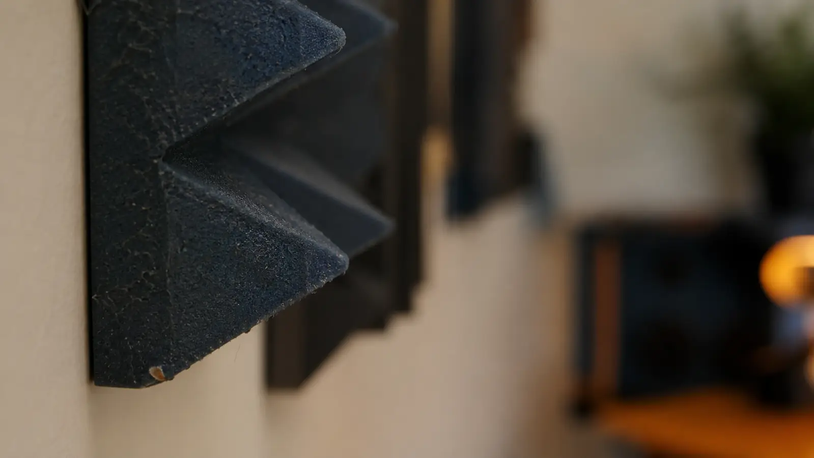 Close-up of an acoustic foam wedge panel corner showing slight fraying after months of use